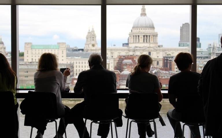 People sat in a cafe with St Pauls Cathedral in the background