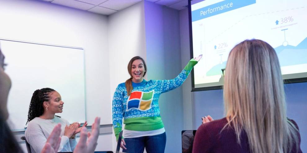 Young girl wearing MS Windows logo sweater presenting in a classroom for a group of people