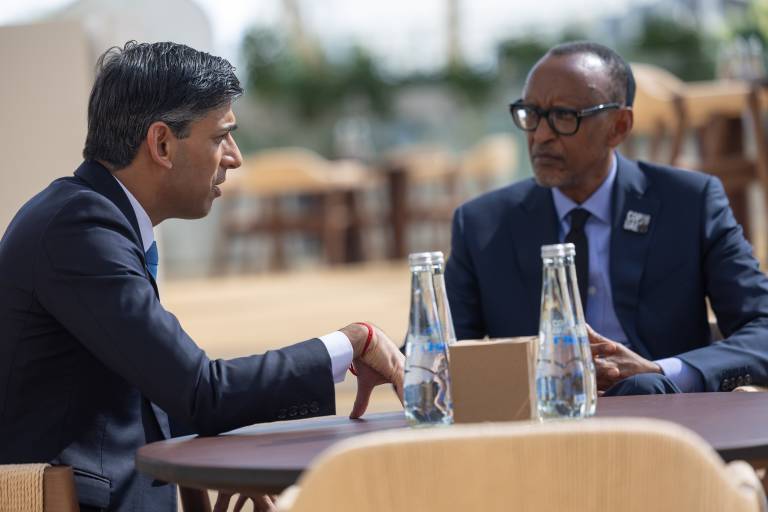 Rishi Sunak and Rwandan President Paul Kagame are sat outside, talking to each other across a small table.