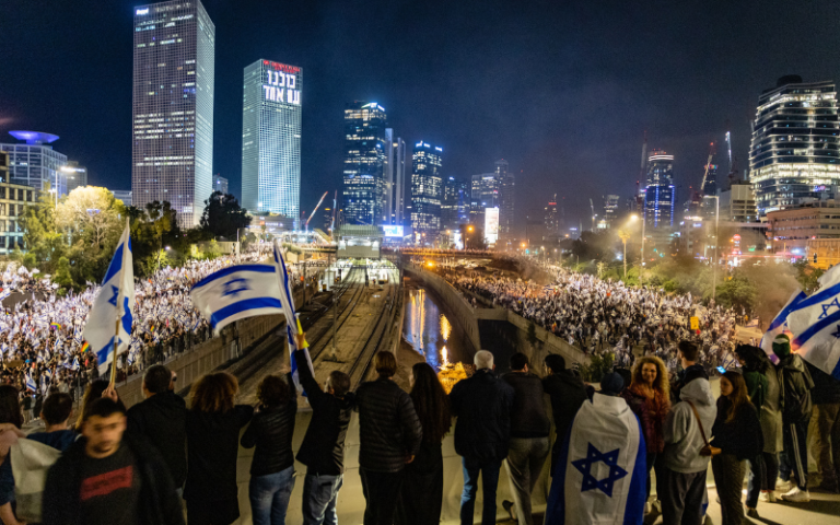 Protesters in Israel, waving Israeli flag