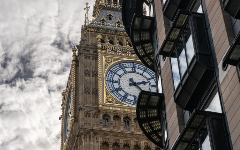 The clock tower of big ben and the corner of Portcullis with a cloudy sky