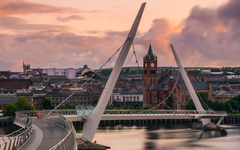 An image of Derry, its river and the Peace Bridge at dusk