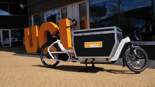 UCL Memory Bike next to orange UCL sign