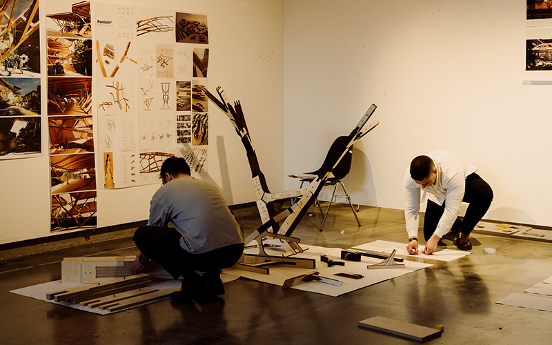 Two students making a model at The Bartlett exhibition