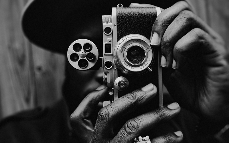 Media Loan Teaser - Man holding vintage camera in Black and White photo