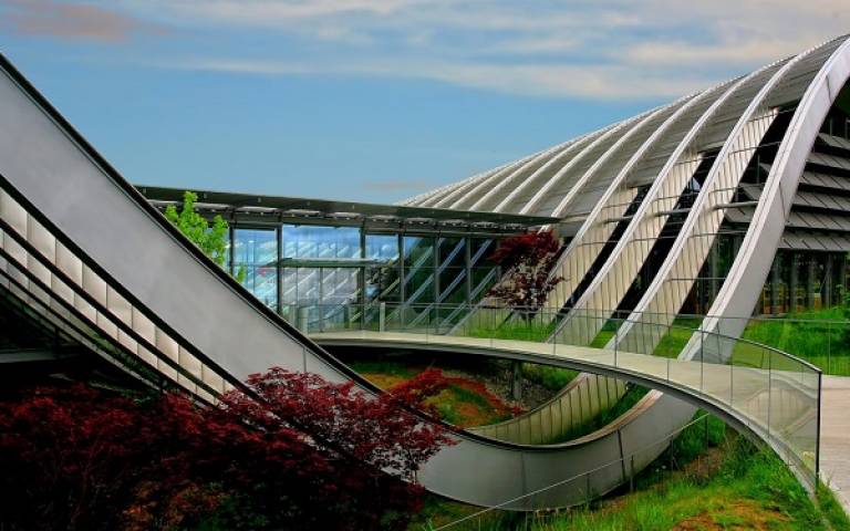 Image of Zentrum Paul Klee museum. There is a metal U-shaped structure with path leading to glass entrance cutting through the middle. 