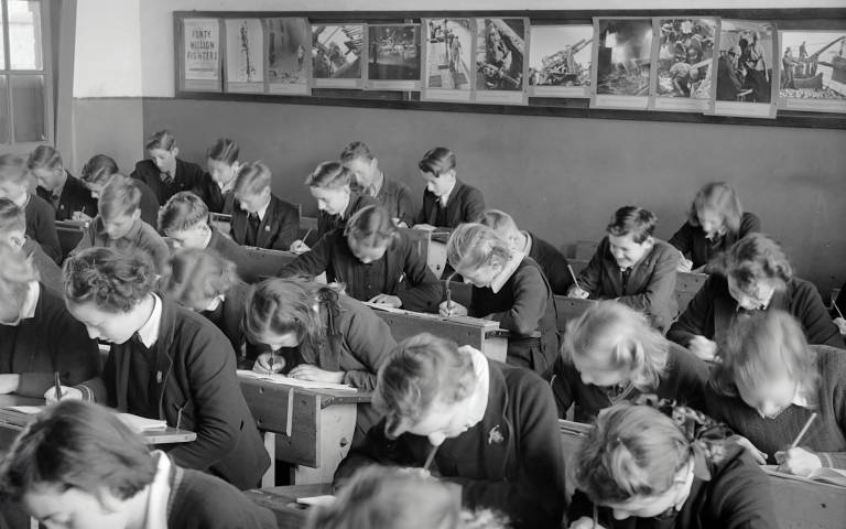 children taking tests in class in black and white