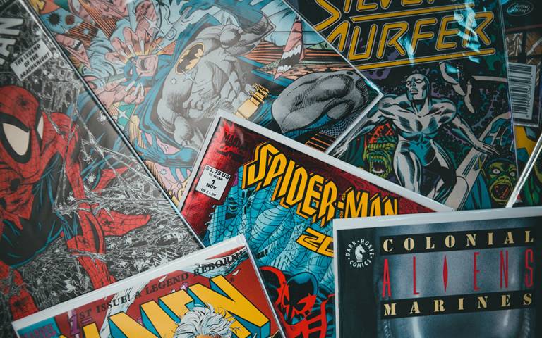 a pile of various comic books i.e silver surfer, batman and spiderman