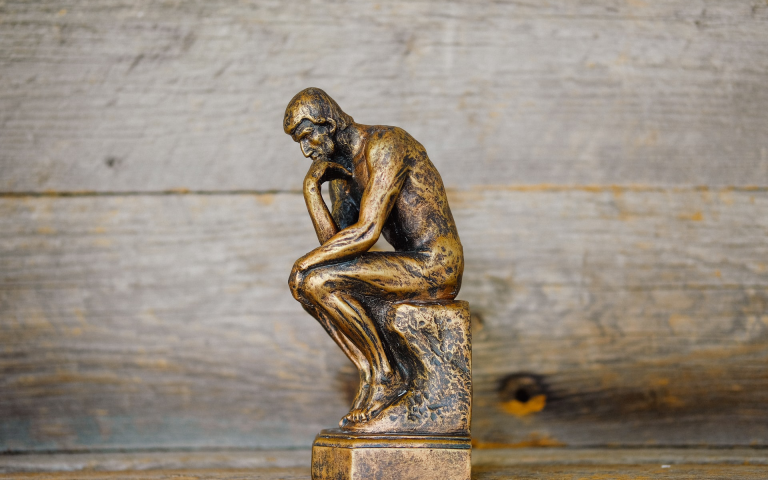 a miniture of "The Thinker" (French: Le Penseur), a bronze sculpture by Auguste Rodin