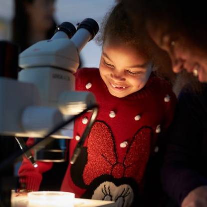 Little girl looking at microscope