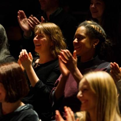Colour photo of women smiling and applauding