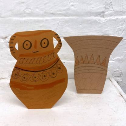 Two pieces of cardboard cut out to look like ancient vases.