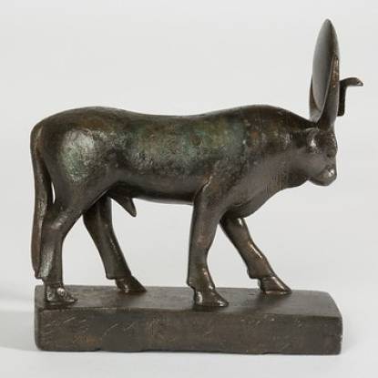 Bronze statuette of the Mnevis bull on a rectangular base. There is a sun disk between his horns and a uraeus cobra. 