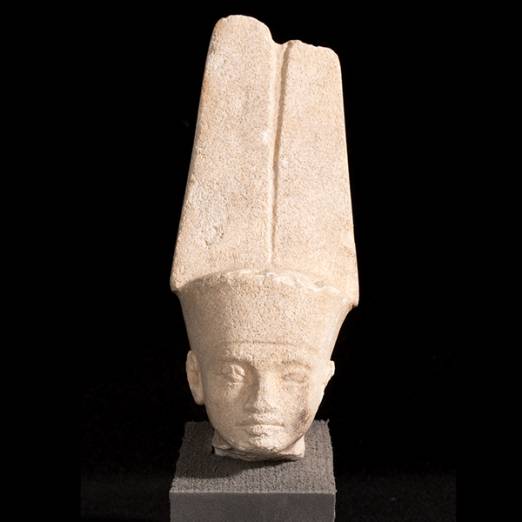 Limestone head of Min-Amun presented on black background