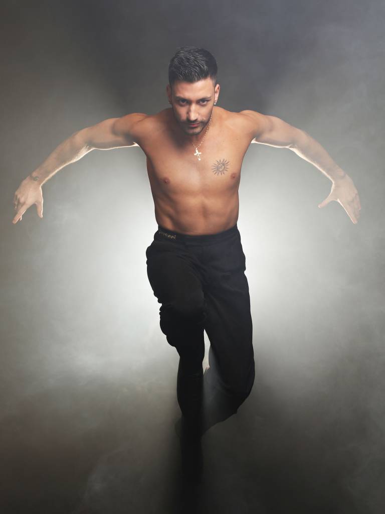 Giovanni Pernice wearing black trouser and no top, leaning towards the camera