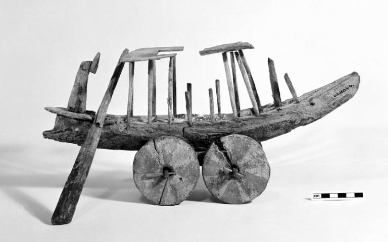 Black and white photograph of an ancient wooden model of a boat.
