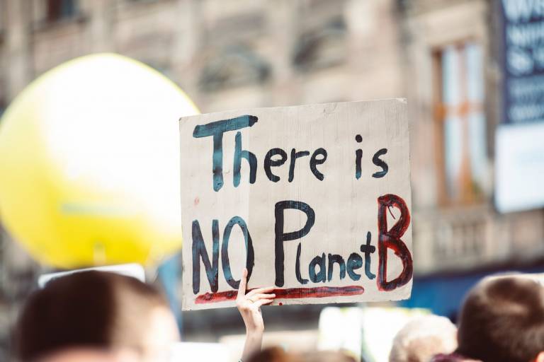 A protestor holds a sign reading There is No Planet B