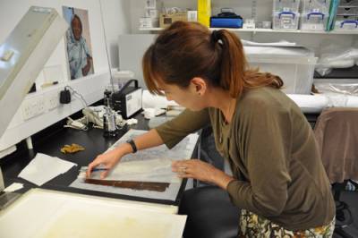 Image of papyrus conservator at work restroing a piece of papyrus