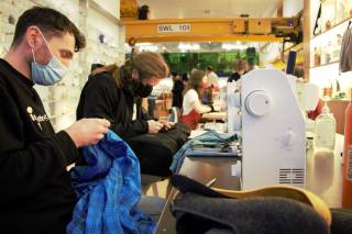 Visitors and staff at the Institute of Making repair clothes as part of a repair cafe in February 2022