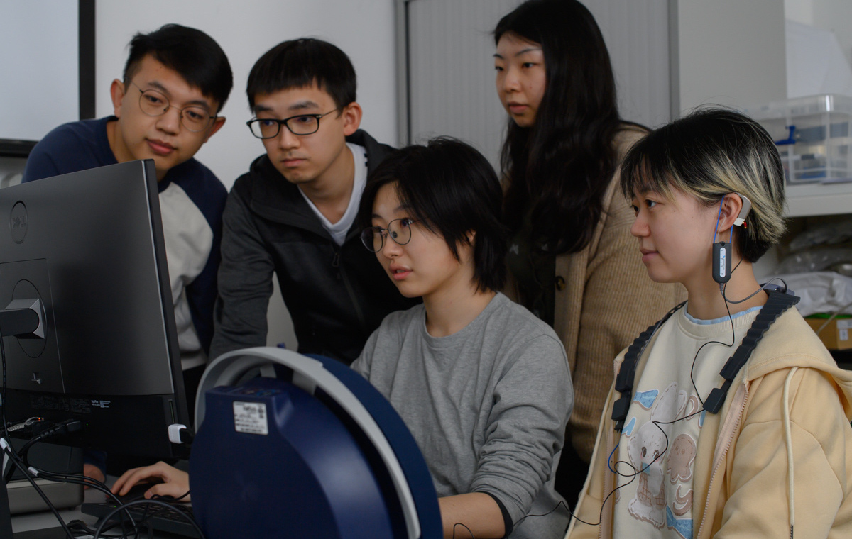 An image of a group of students focussing on a computer screen