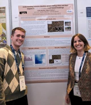 Blake O'Sullivan and Linda Jakschies, two UCL masters students, stand either side of a conference poster.
