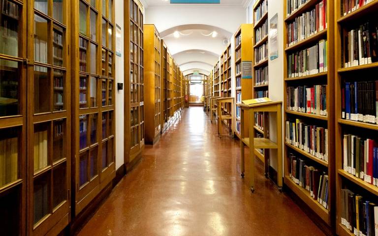 looking down a long corridor with rows of books either side