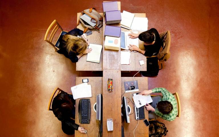 birdseye view of four students studying in the library