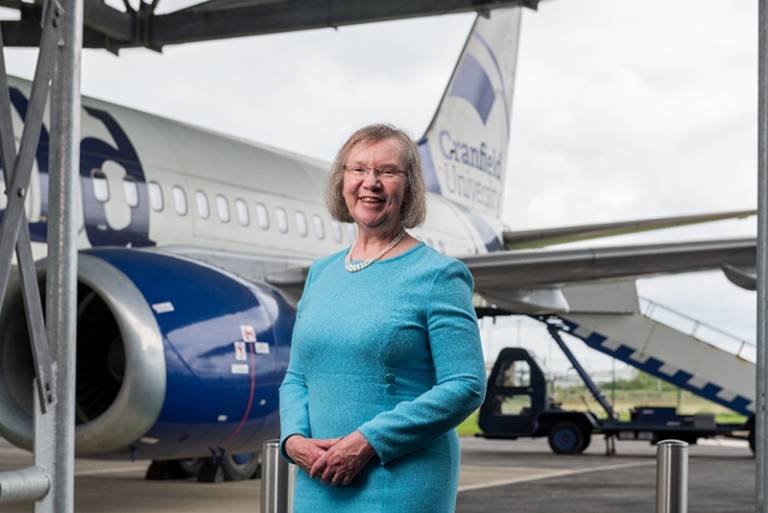 Image of Dame Helen Atkinson standing infront of a plane