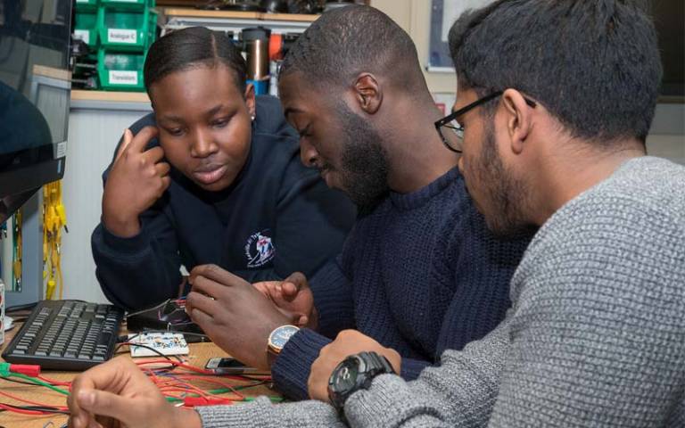Three EEE students analysing an electronic gadget