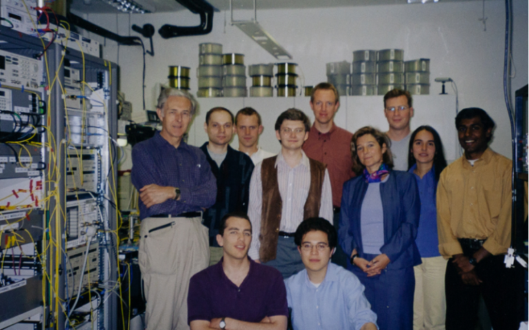 Group photo of Professor John Midwinter and colleagues in the optical communications lab at UCL