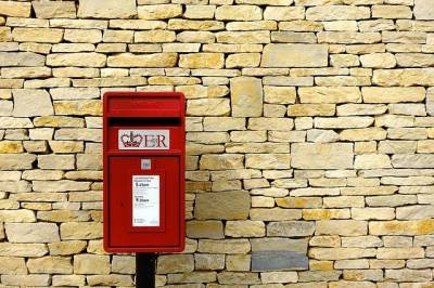 Photo of a red post box against a brick wall