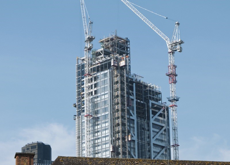 An image of a construction crane and a tower block