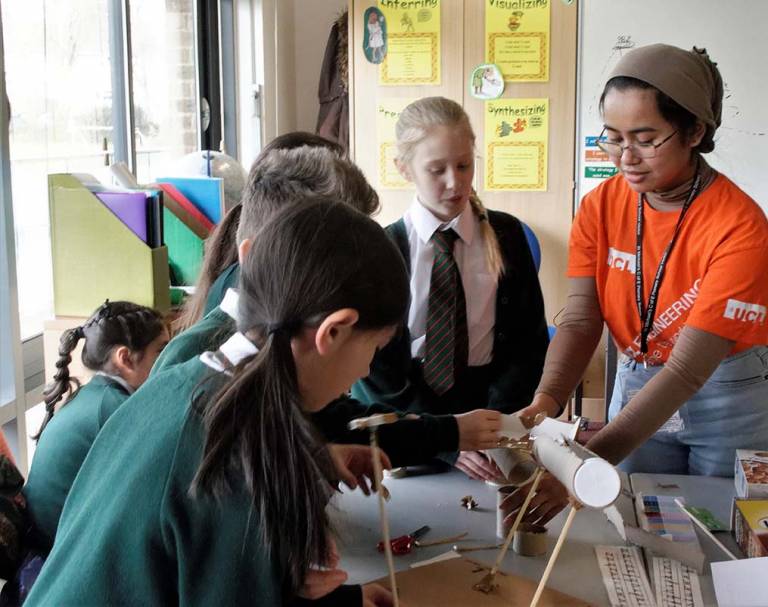 A UCL Engineering student volunteer leading an outreach session for schoolchildren.