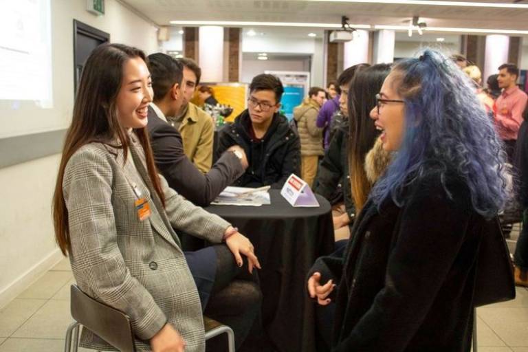 Student sitting at a table and chatting at a careers event.