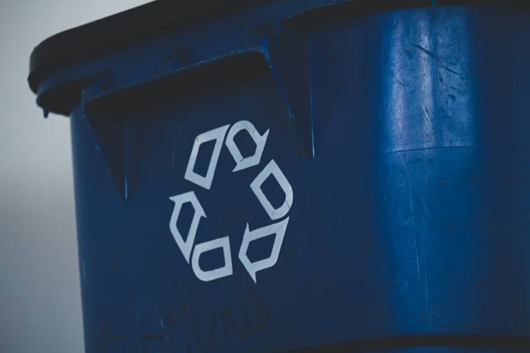Close up of a blue recycling bin showing the circular arrow logo.