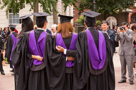 Students on graduation day in gowns backs to camera