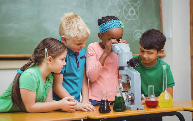 A group of children using a microscope - photo from Shutterstock 