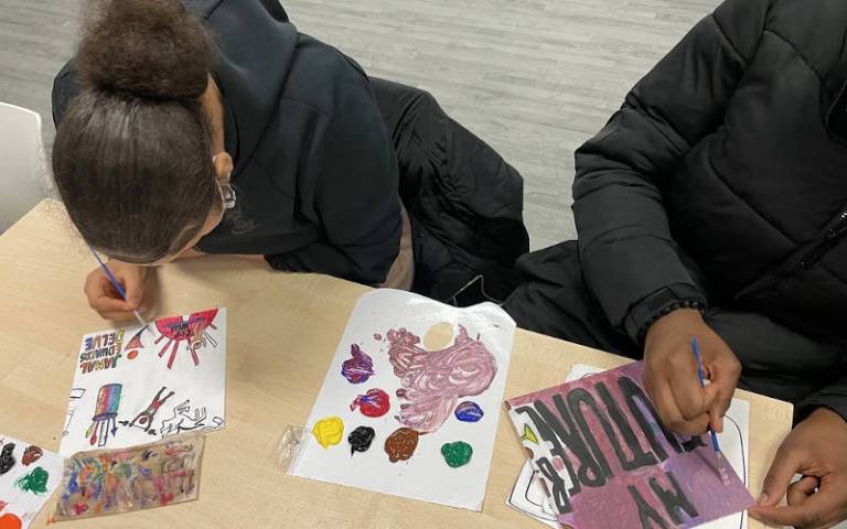 Two young people working on art at a workshop