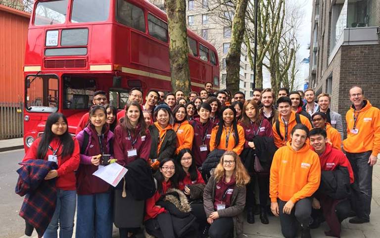 A group of UCL students standing in front of a red London bus, taking part in the London Venture Crawl 2019