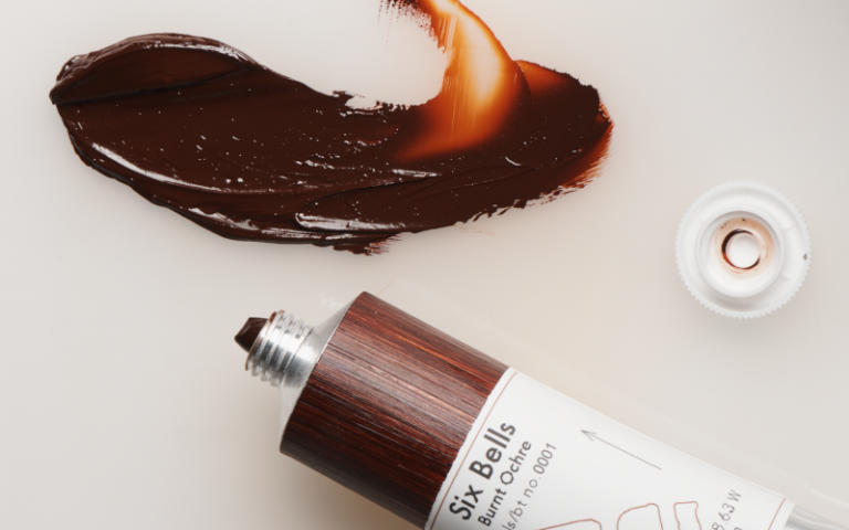 A smudge of brown paint, next to a tube labelled 'Six Bells Burnt Ochre'