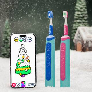 Two toothbrushes next to a phone displaying the Playbrush app