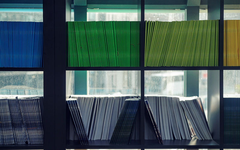 Green and blue files on a shelf