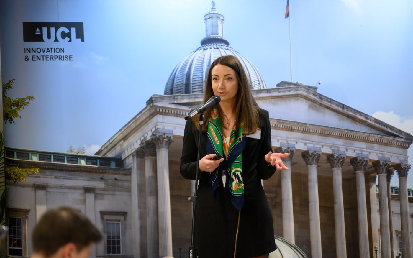 Photograph of Evelina Balt speaking with a microphone.