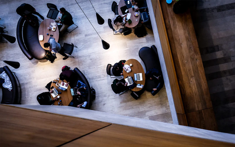 A group of students clustered around tables viewed from above