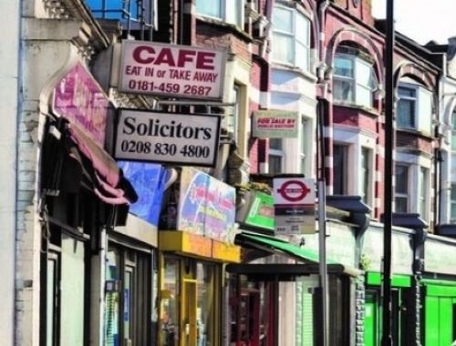 Photograph of a town centre with cafe and solicitors signs.