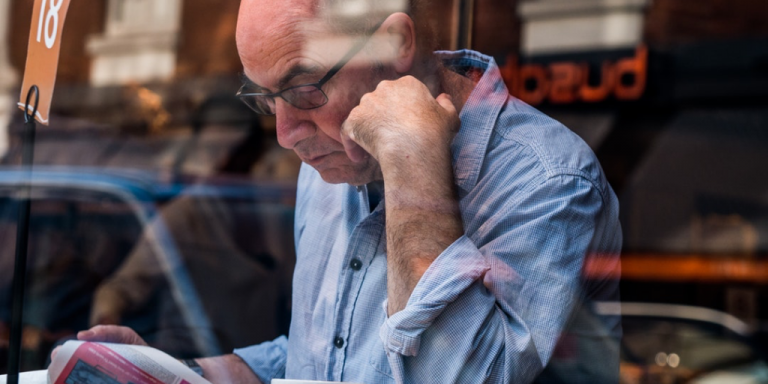 older man reading a newspaper