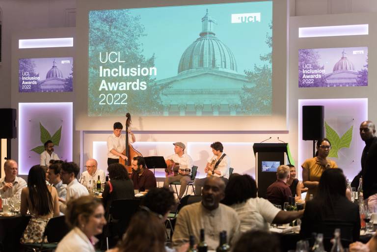 Photograph of staff and students seated at their tables at the awards ceremony. A swing band is on stage playing music, while guests await the start of the ceremony.