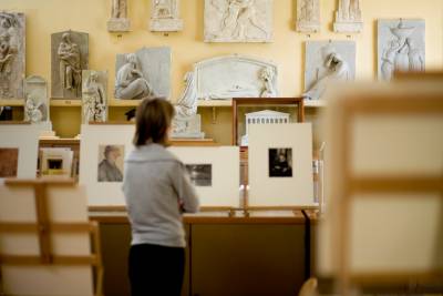 A woman peruses sculptures in the UCL art museum