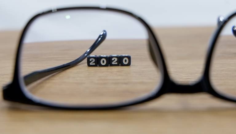 An image of a pair of glasses and through the frame are 4 blocks with the numbers 2020 on them.