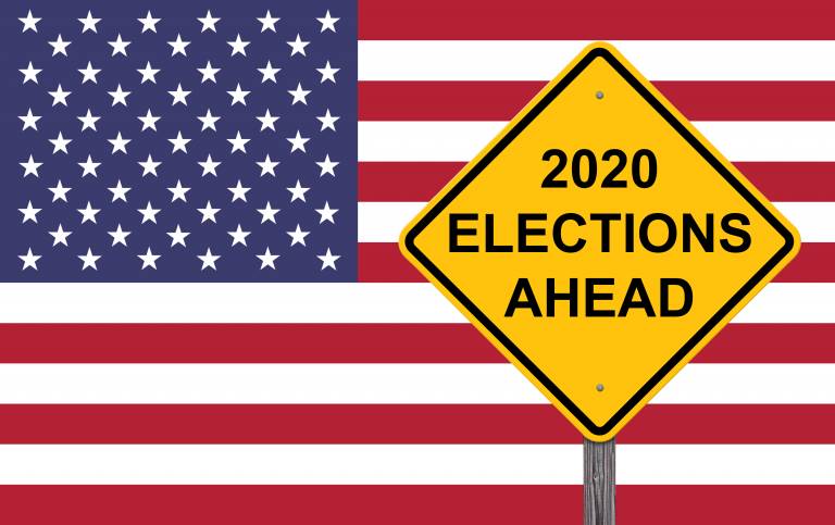 A road sign with the words '2020 Elections Ahead' in front of an American flag